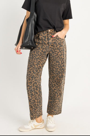 Woman wearing a black t-shirt and leopard print pants on a white background