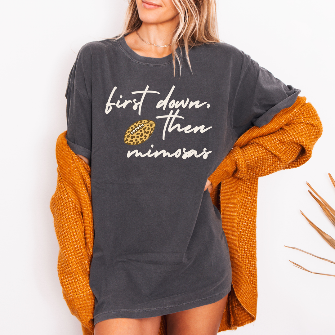 Person wearing a dark gray sweatshirt with text and a pineapple graphic, paired with an orange cardigan.