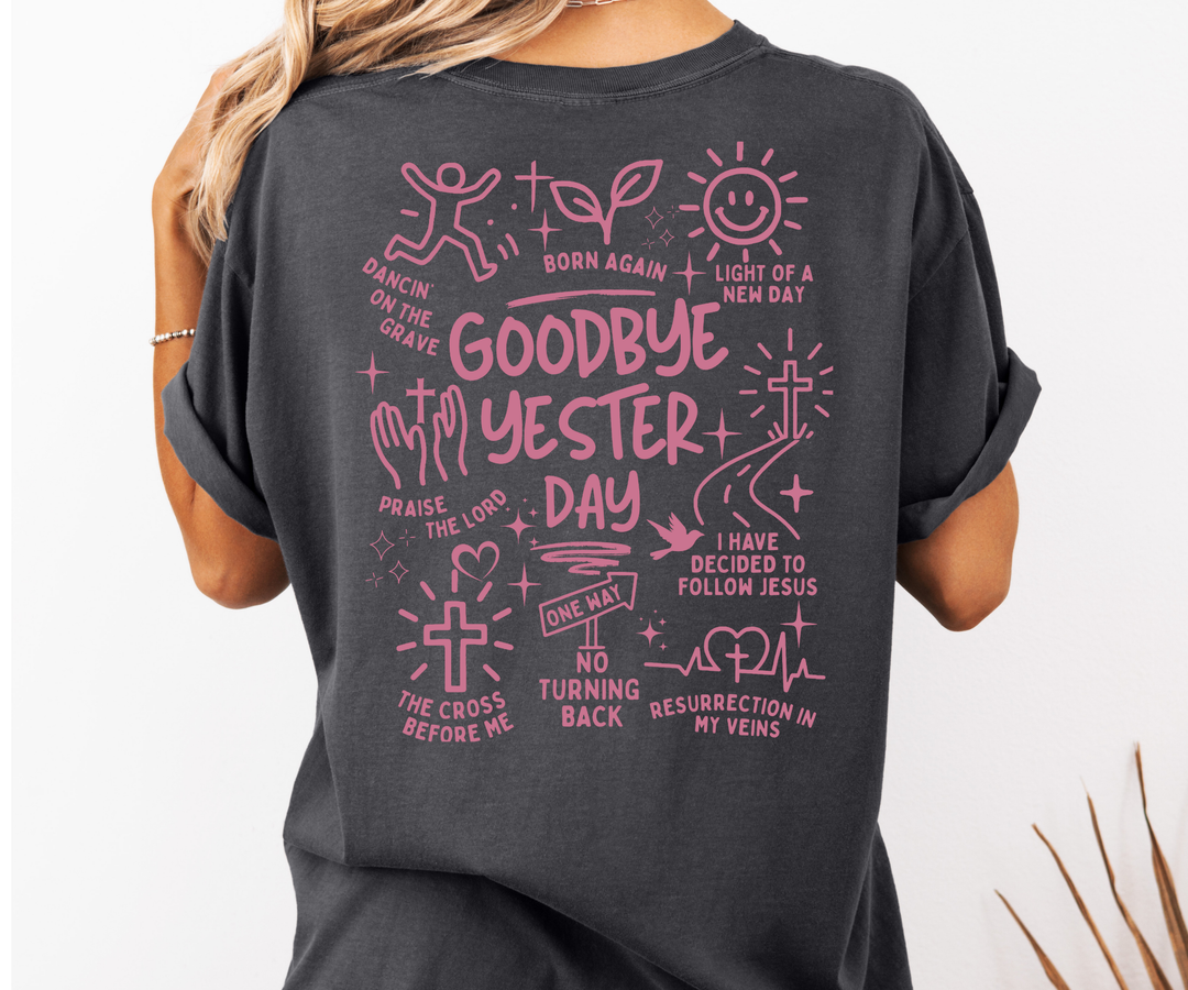 Person wearing a dark gray t-shirt with pink graphic designs and text on the back.