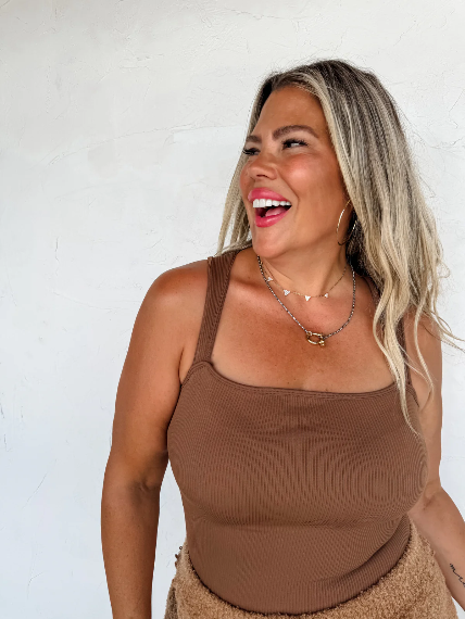 Woman wearing a brown tank top against a white background
