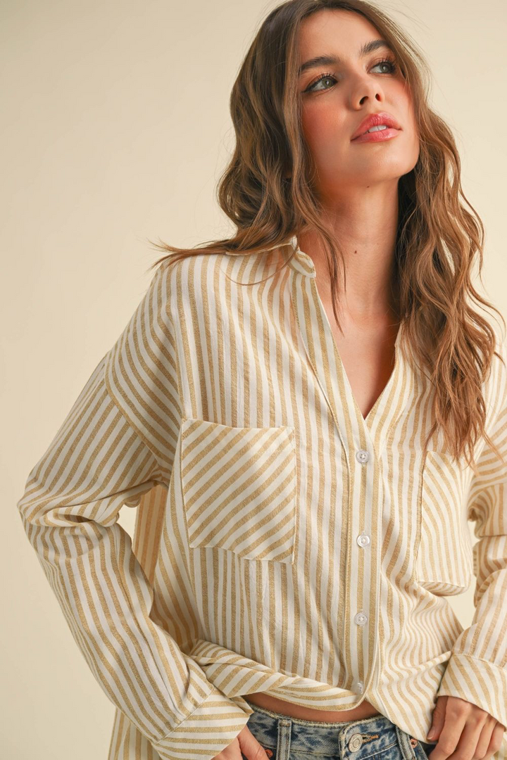 Woman wearing a beige and white striped shirt against a beige background