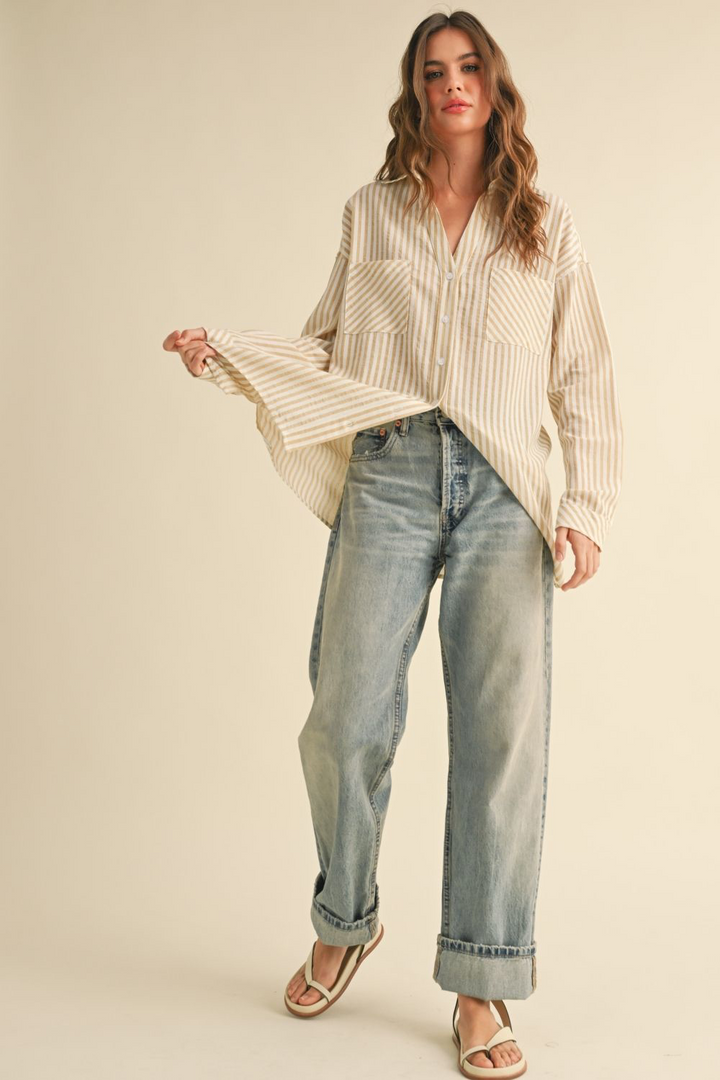 Woman wearing a striped shirt and jeans on a beige background